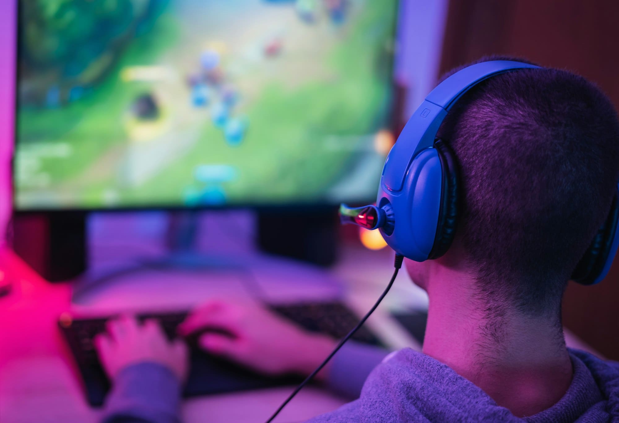 Young gamer playing online video games while streaming on social media